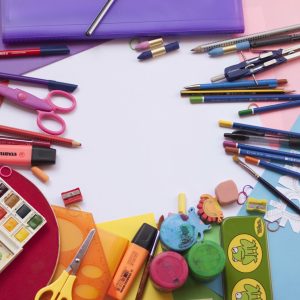 A vibrant selection of school supplies on a desk, including paints and stationery, ideal for creative projects.