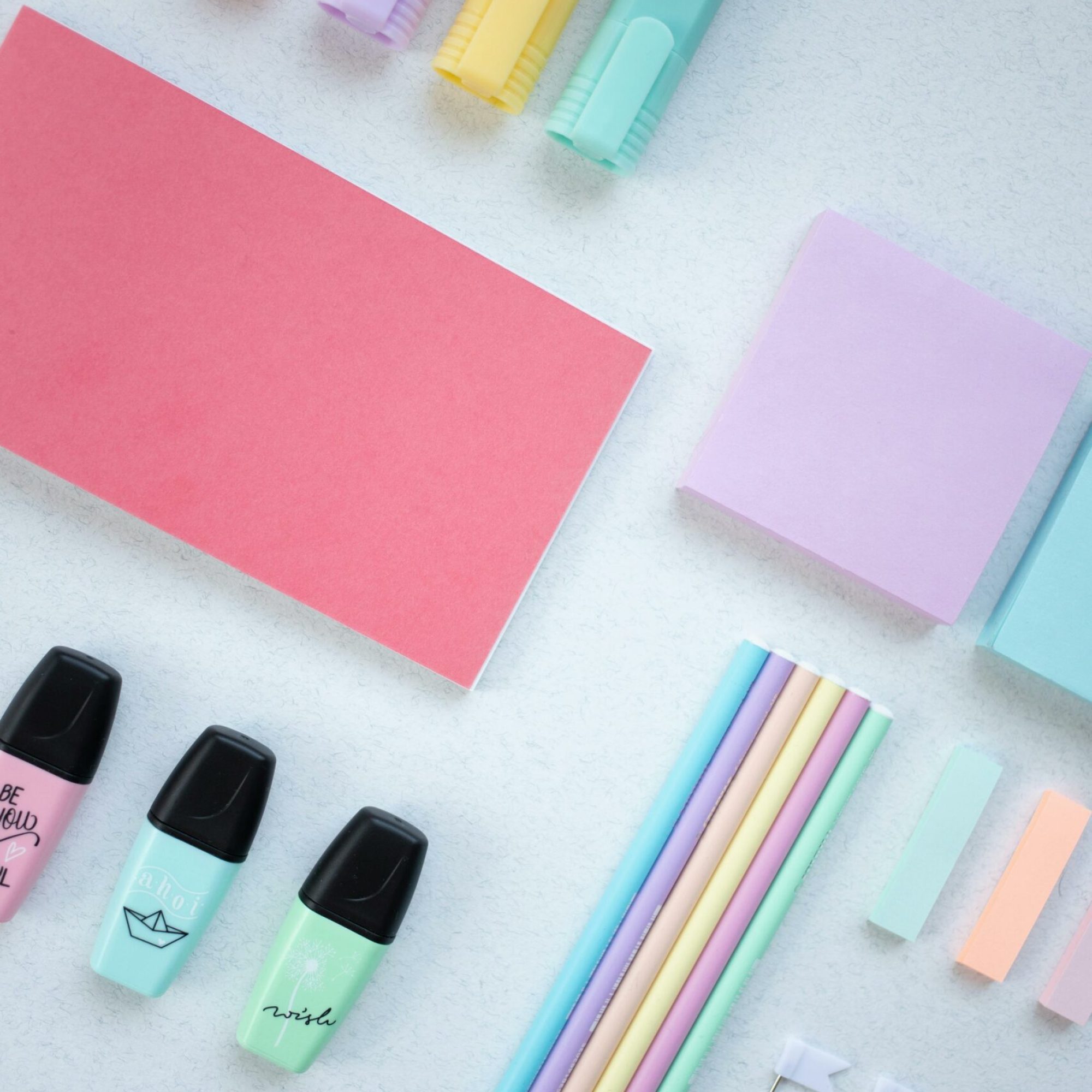 An artistic flat lay of colorful stationery items on a white surface, perfect for school and office themes.
